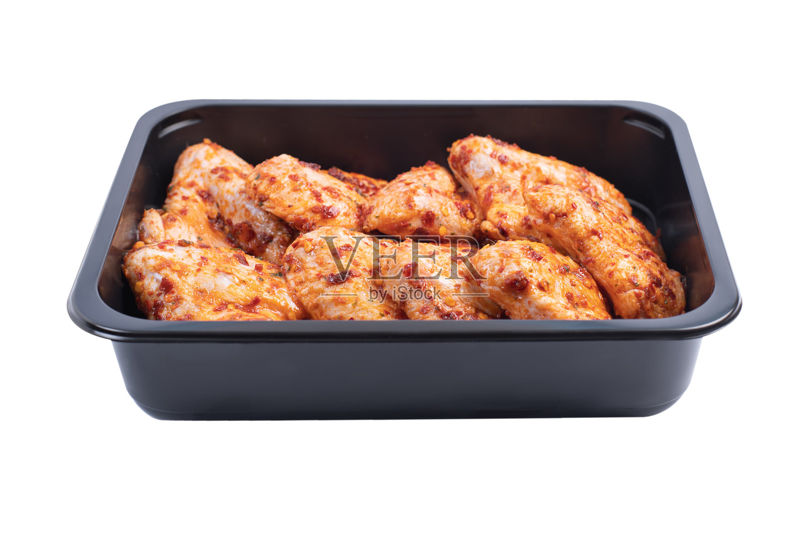 红腌鸡翅，零售包装。在一个孤立的背景下为超市准备的生鸡翅。腌鸡翅特写。从以上观点。照片摄影图片