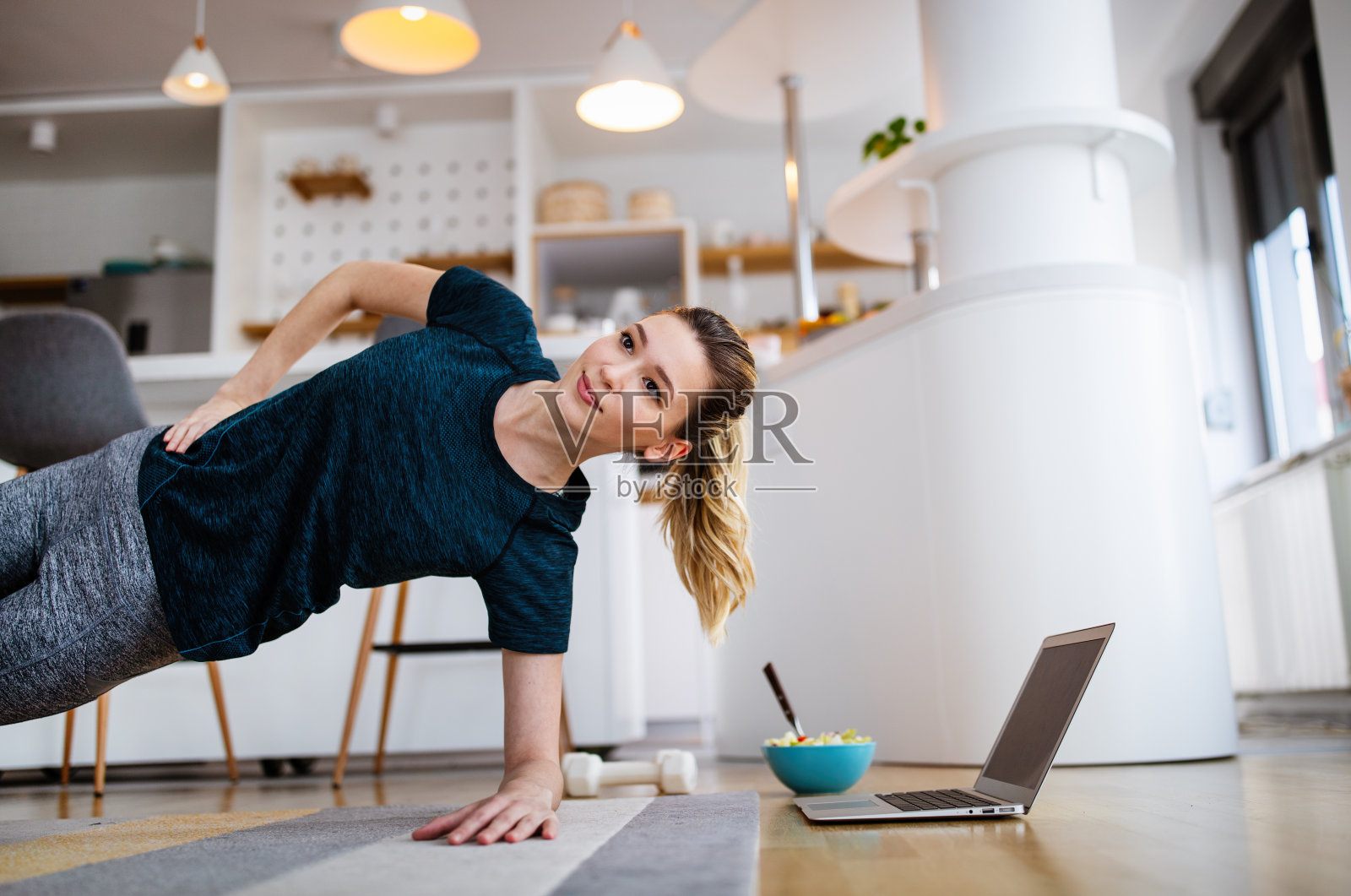 美丽的年轻女子在家里做瑜伽，健身运动照片摄影图片
