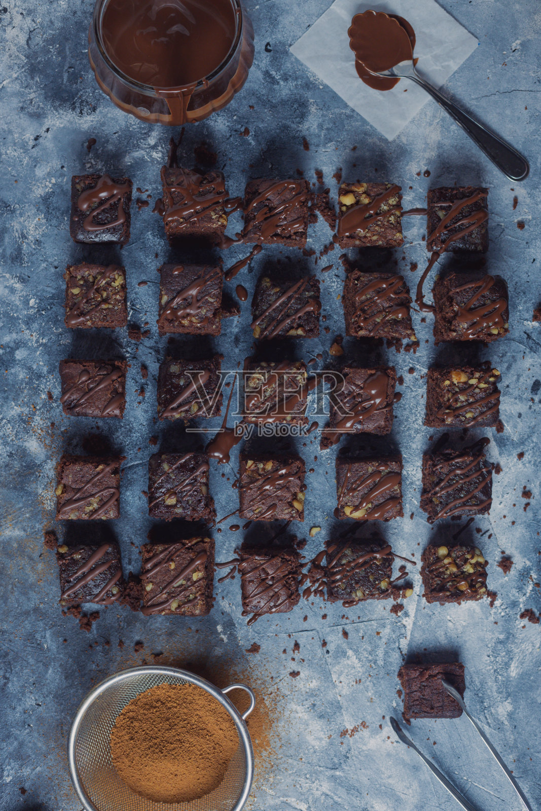 蓝色纹理表面上覆盖着巧克力的布朗尼块照片摄影图片