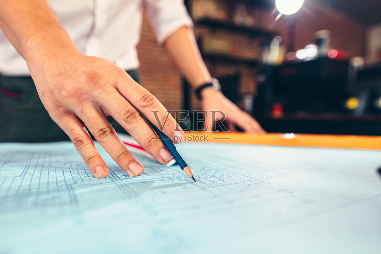 工程师们拿着一支笔指着一座建筑，并绘制出施工计划，为建筑商提供详细的指导。负责工程设计和图纸编写。照片摄影图片