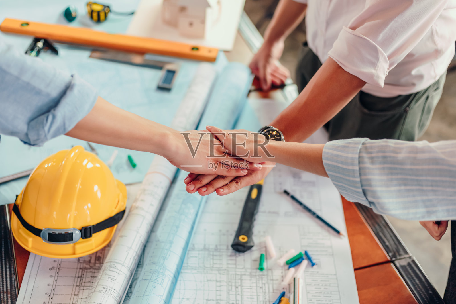 工程师和建筑师合作伙伴团队一起工作。群人双手协作，信任业务。照片摄影图片