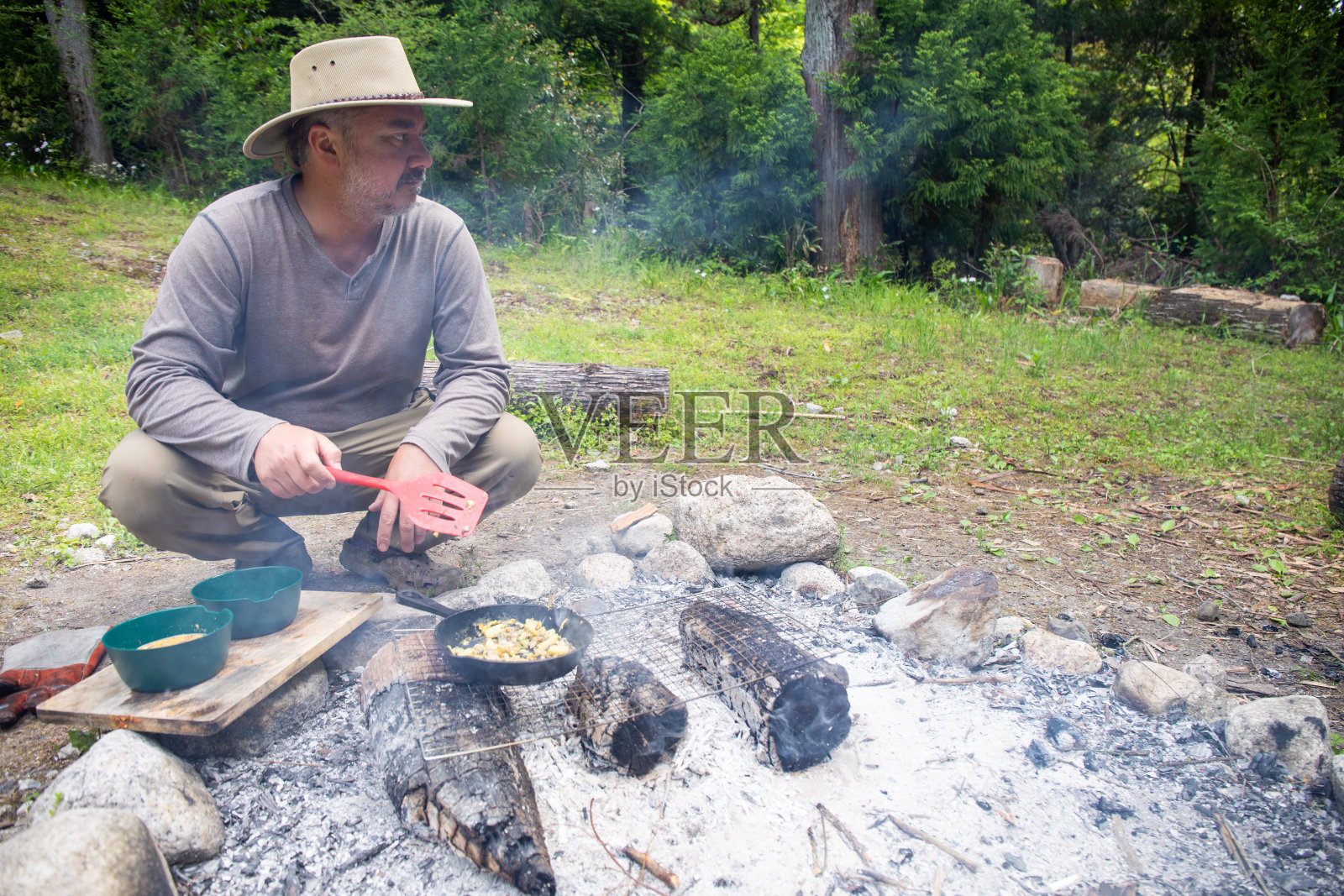 一个男人在野外生火做饭照片摄影图片