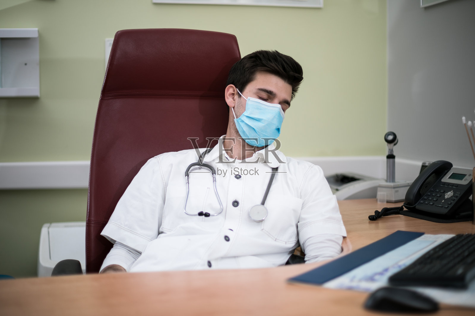 劳累过度的男医务人员正在医院的椅子上打盹照片摄影图片