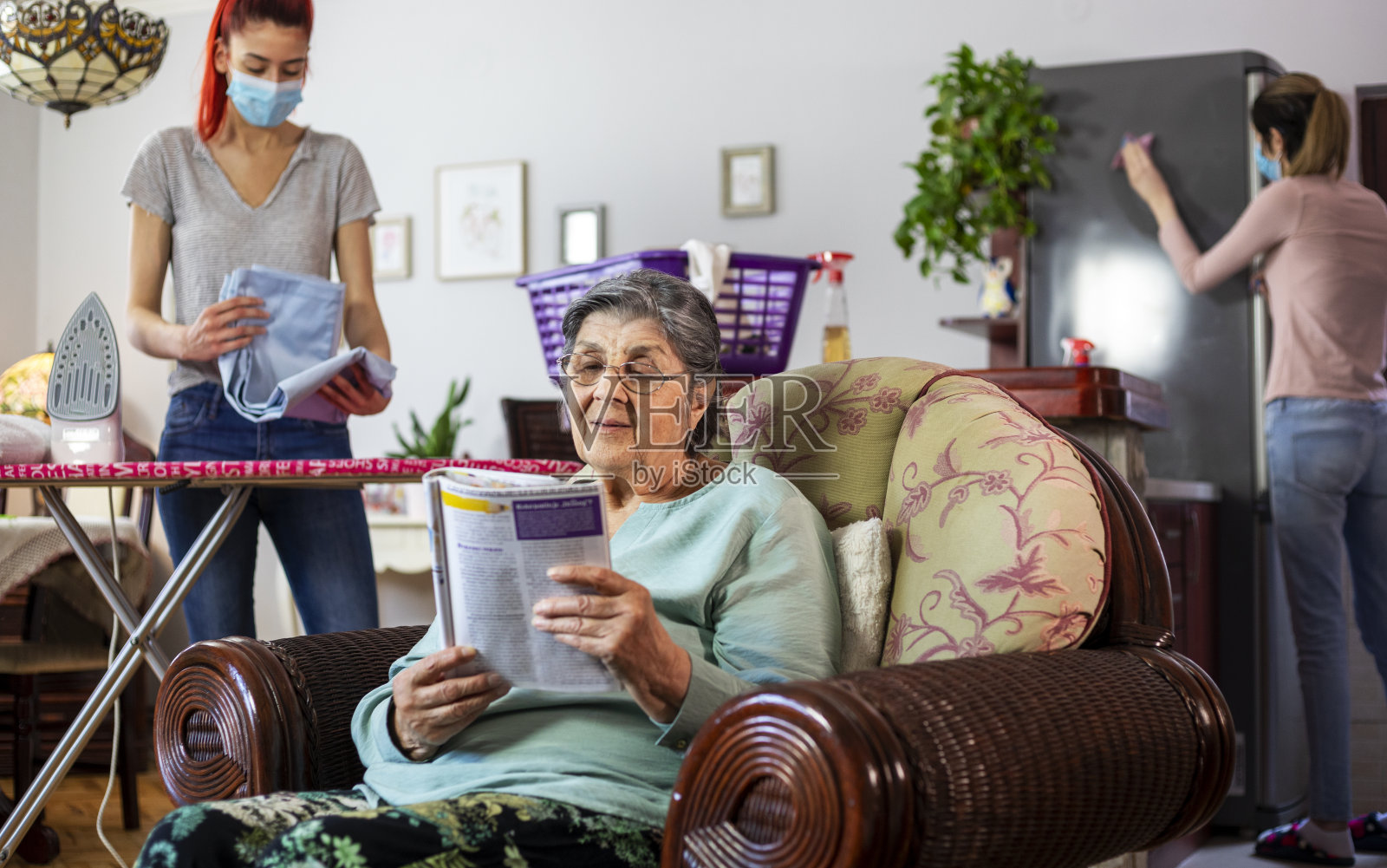 为老年妇女打扫房子的家政助手照片摄影图片