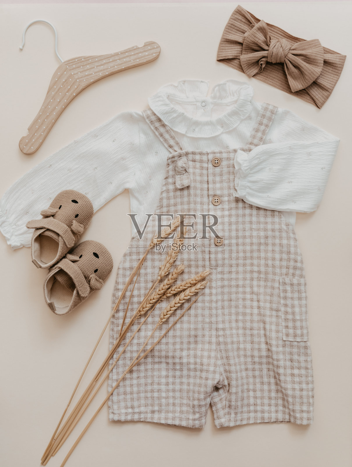 时尚婴儿服装米色背景。天然亚麻织物，环保。波西米亚风格的儿童，俯视图，平躺。照片摄影图片