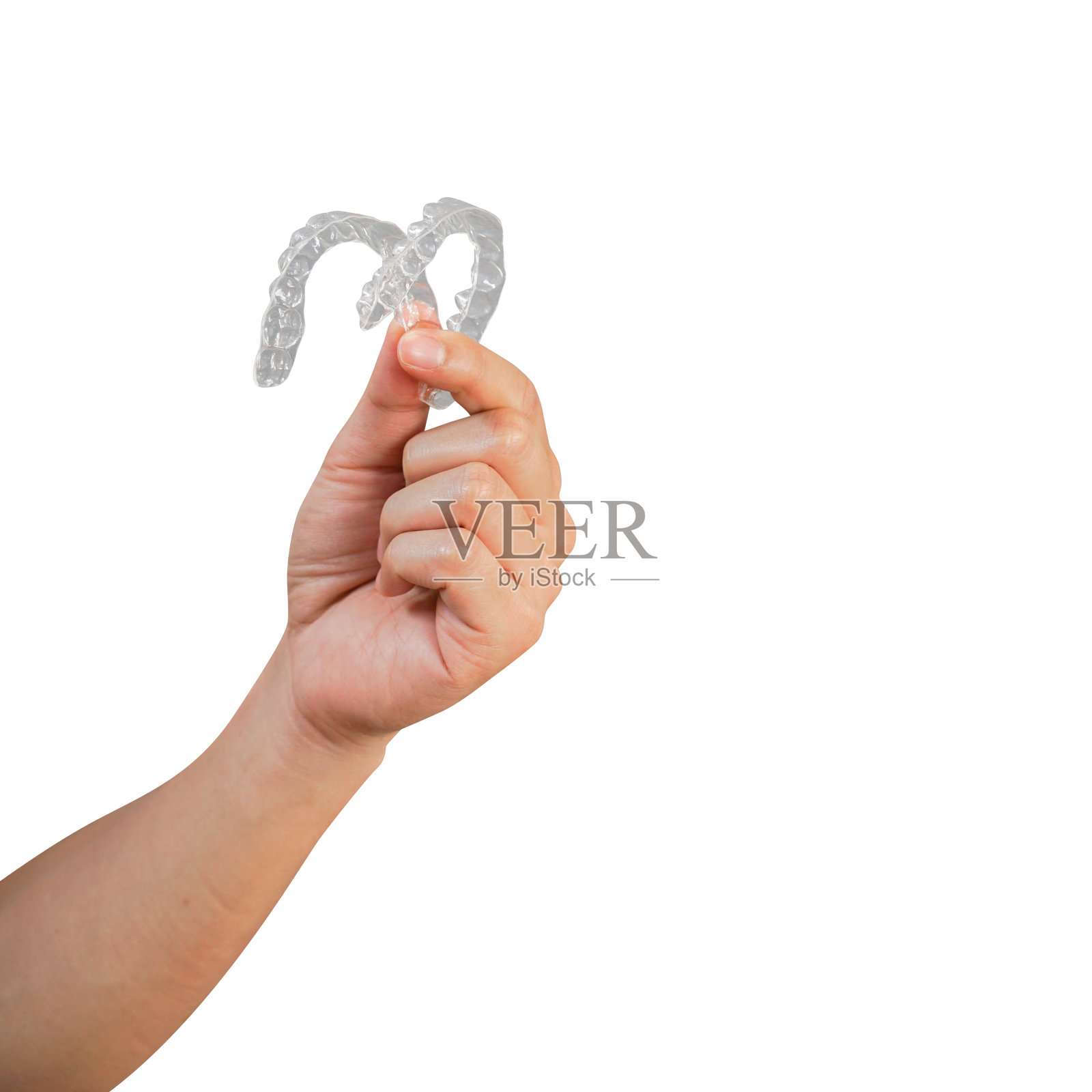 近手握住显示牙科对准器固位器工具(看不见)孤立在白色背景美丽的牙齿治疗过程的概念照片摄影图片