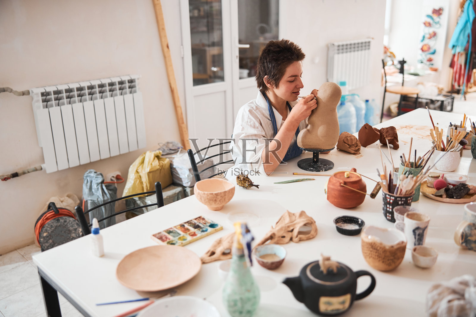 陶工参与雕刻脸部的泥塑照片摄影图片