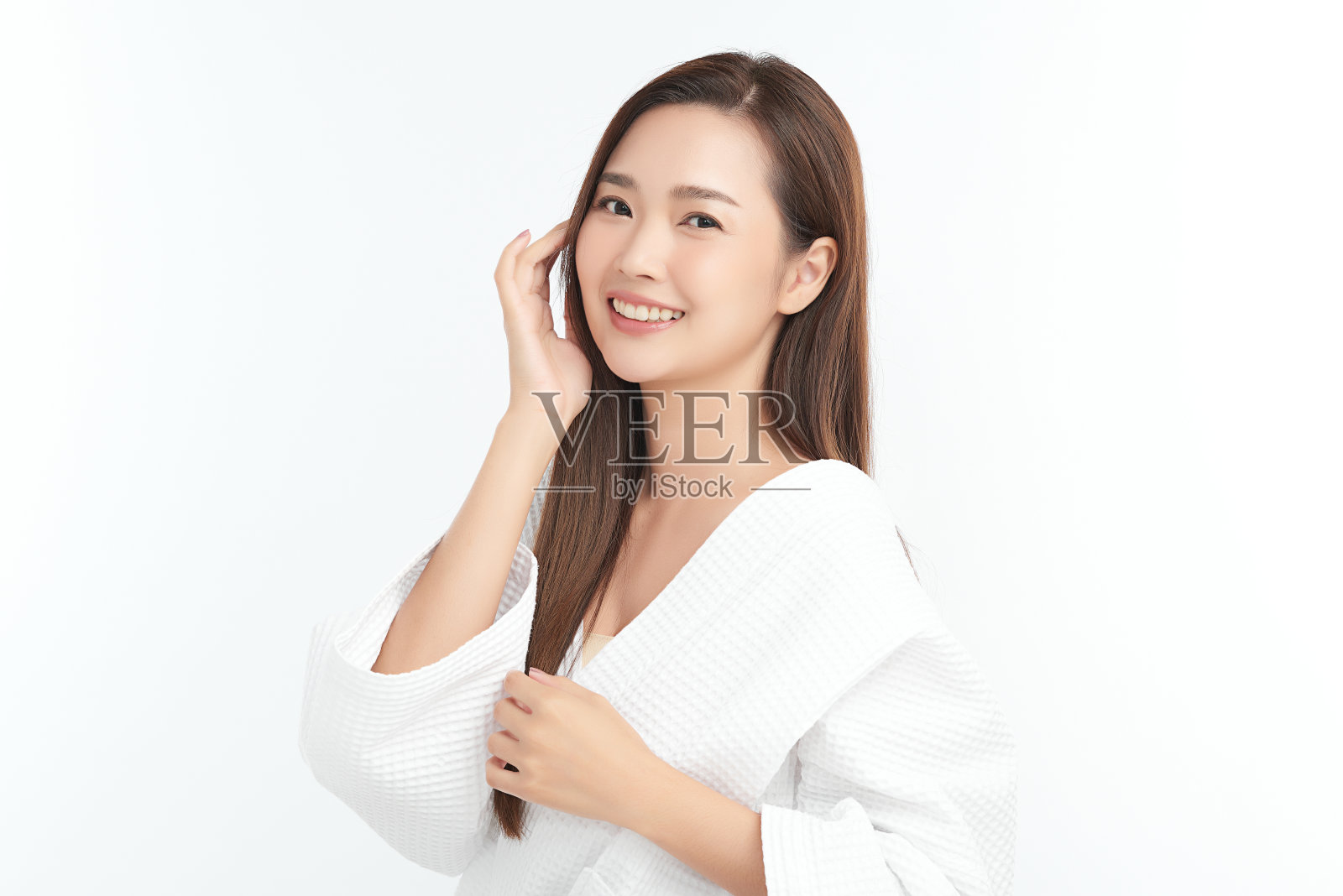 美丽年轻的亚洲女人穿着浴衣在白色的背景，面部护理，面部治疗，美容，美容和水疗概念。照片摄影图片