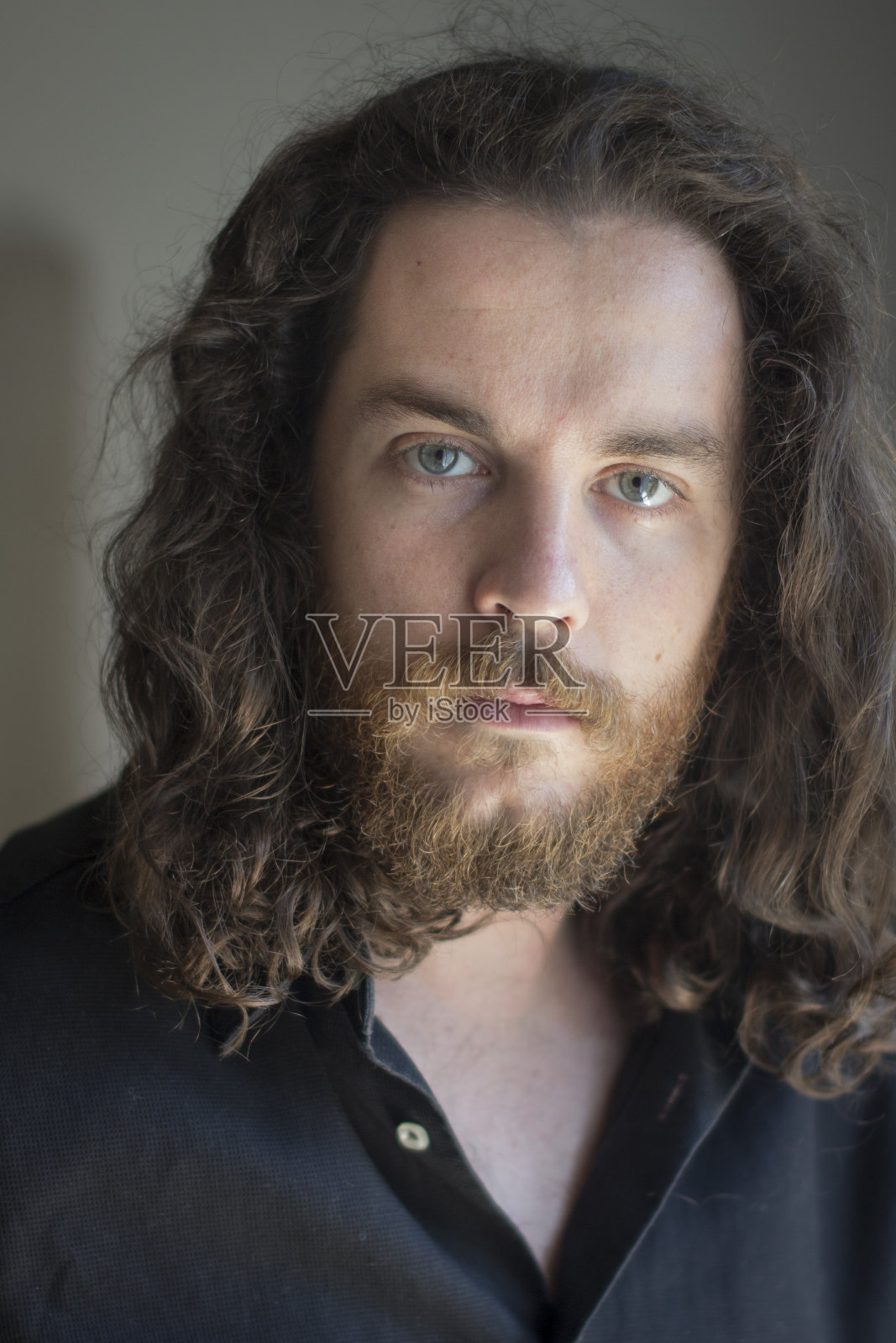 灰色眼睛，胡子和棕色长发的男人。照片摄影图片