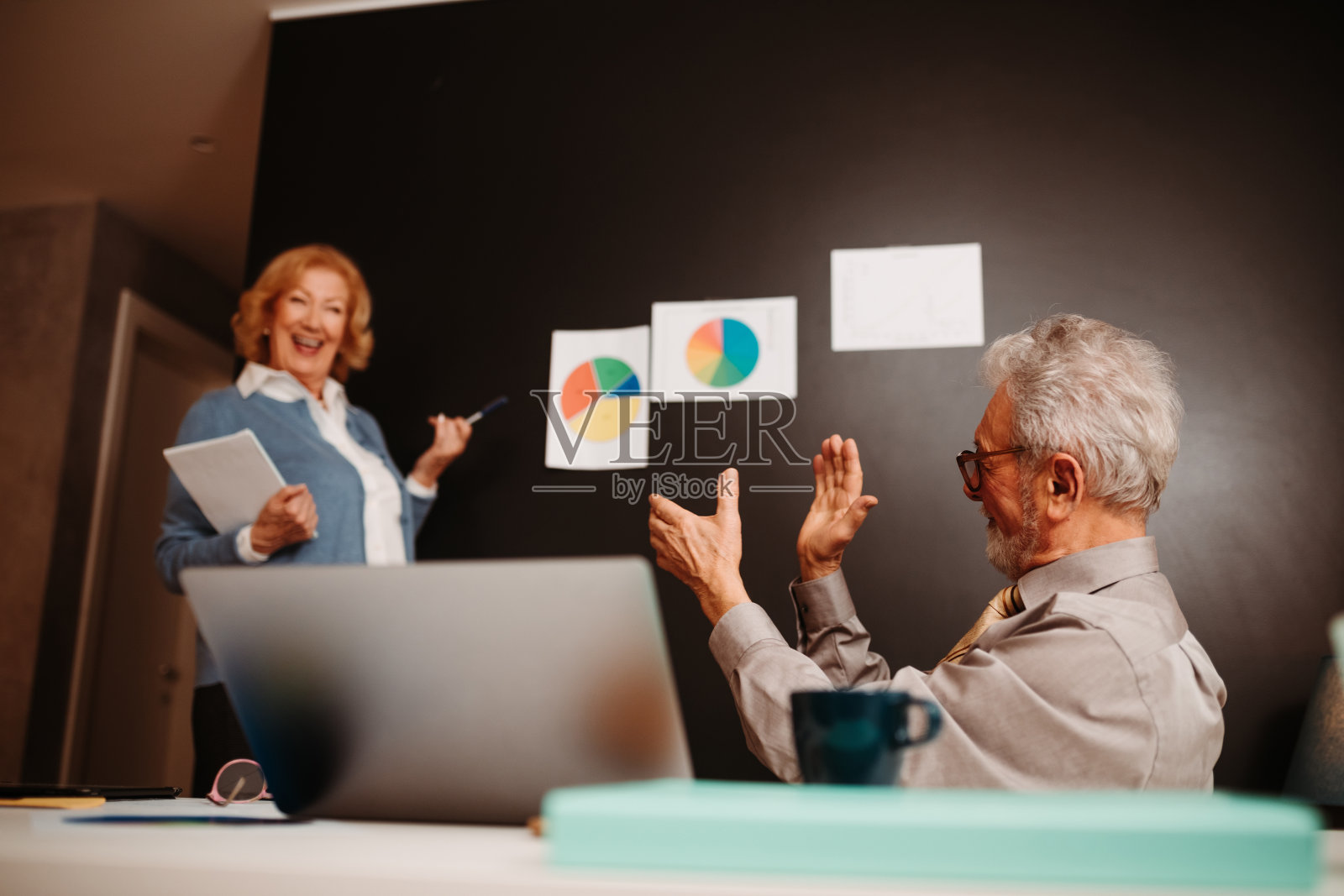 妻子在家里练习业务演示，而丈夫倾听并建议她。照片摄影图片