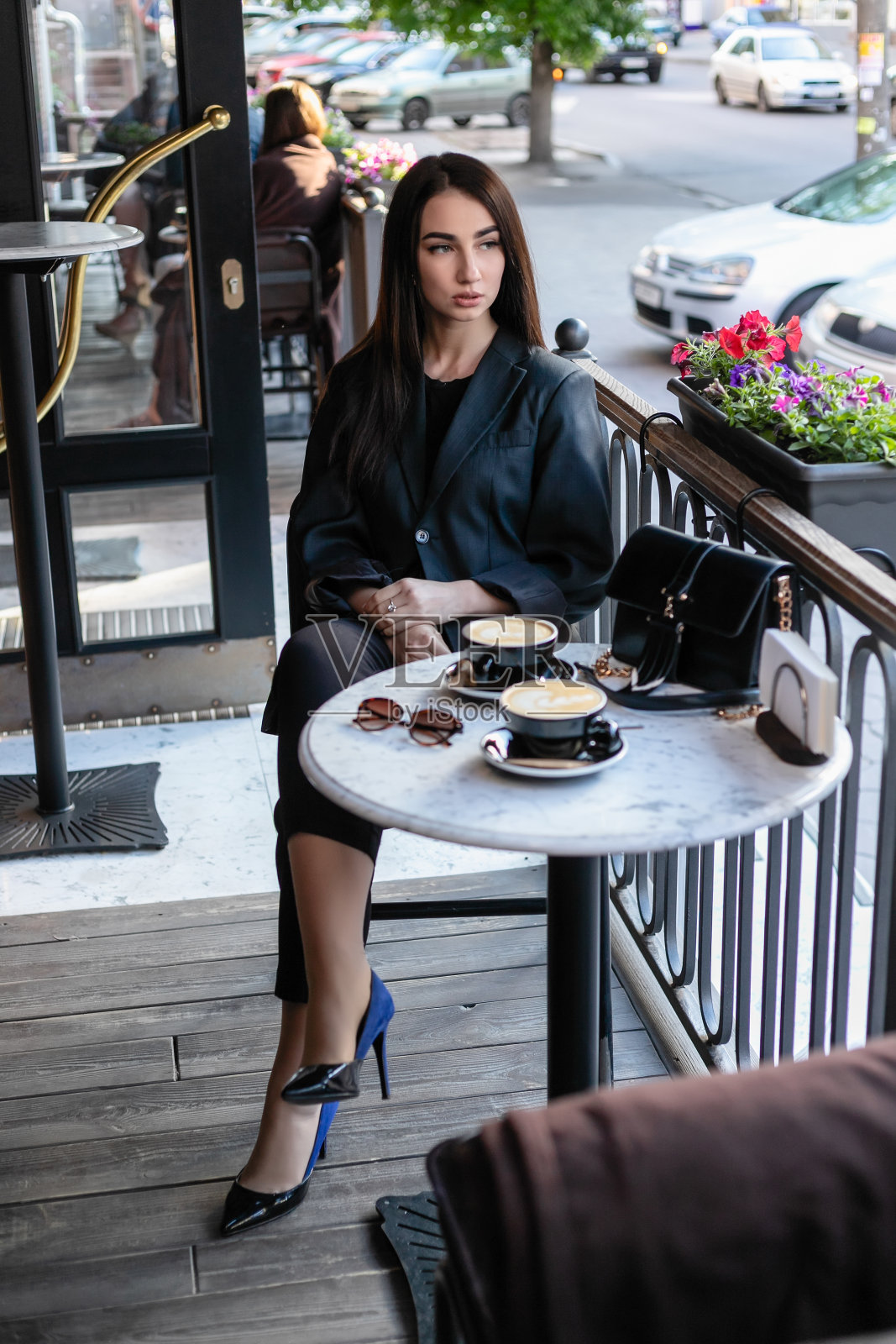 戴着墨镜的女孩坐在咖啡厅，咖啡厅照片摄影图片