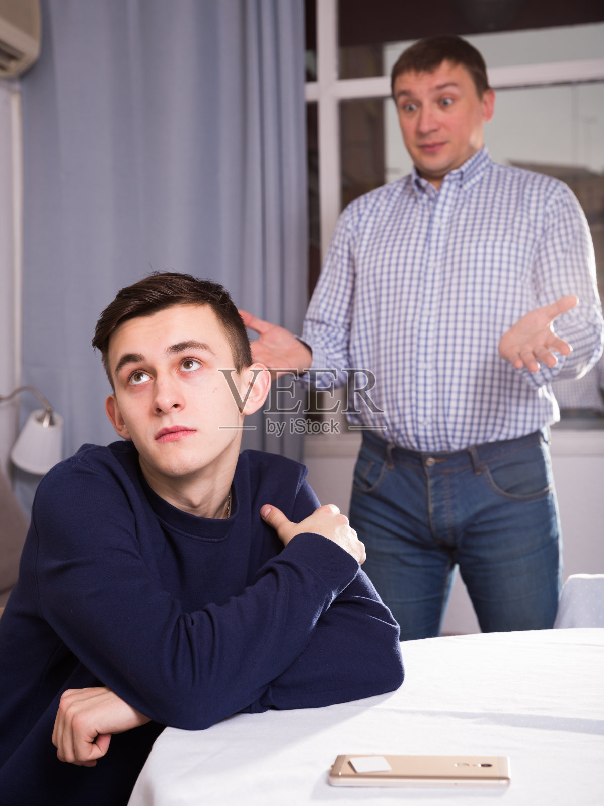 男孩被冒犯了，父亲请求他的原谅照片摄影图片