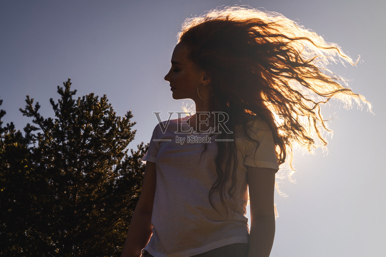 阳光下留着长发的快乐女人。照片摄影图片