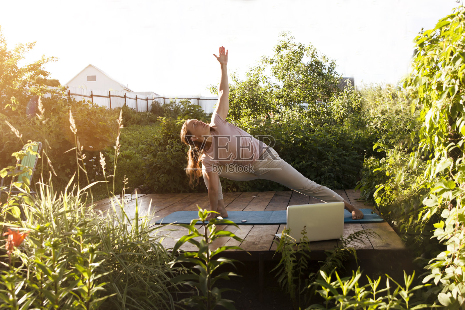 一个在户外练瑜伽的女人，在网上上笔记本电脑课。健康的生活方式的概念。独奏户外活动。照片摄影图片