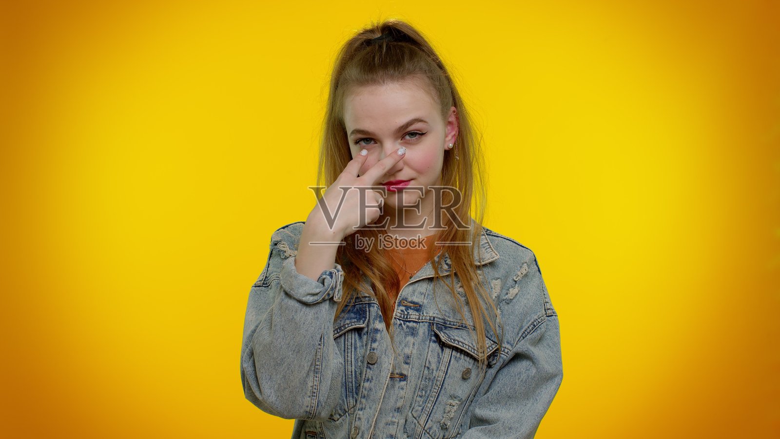 年轻时尚的女孩指着她的眼睛和相机，显示我正在看着你的手势，监视某人照片摄影图片