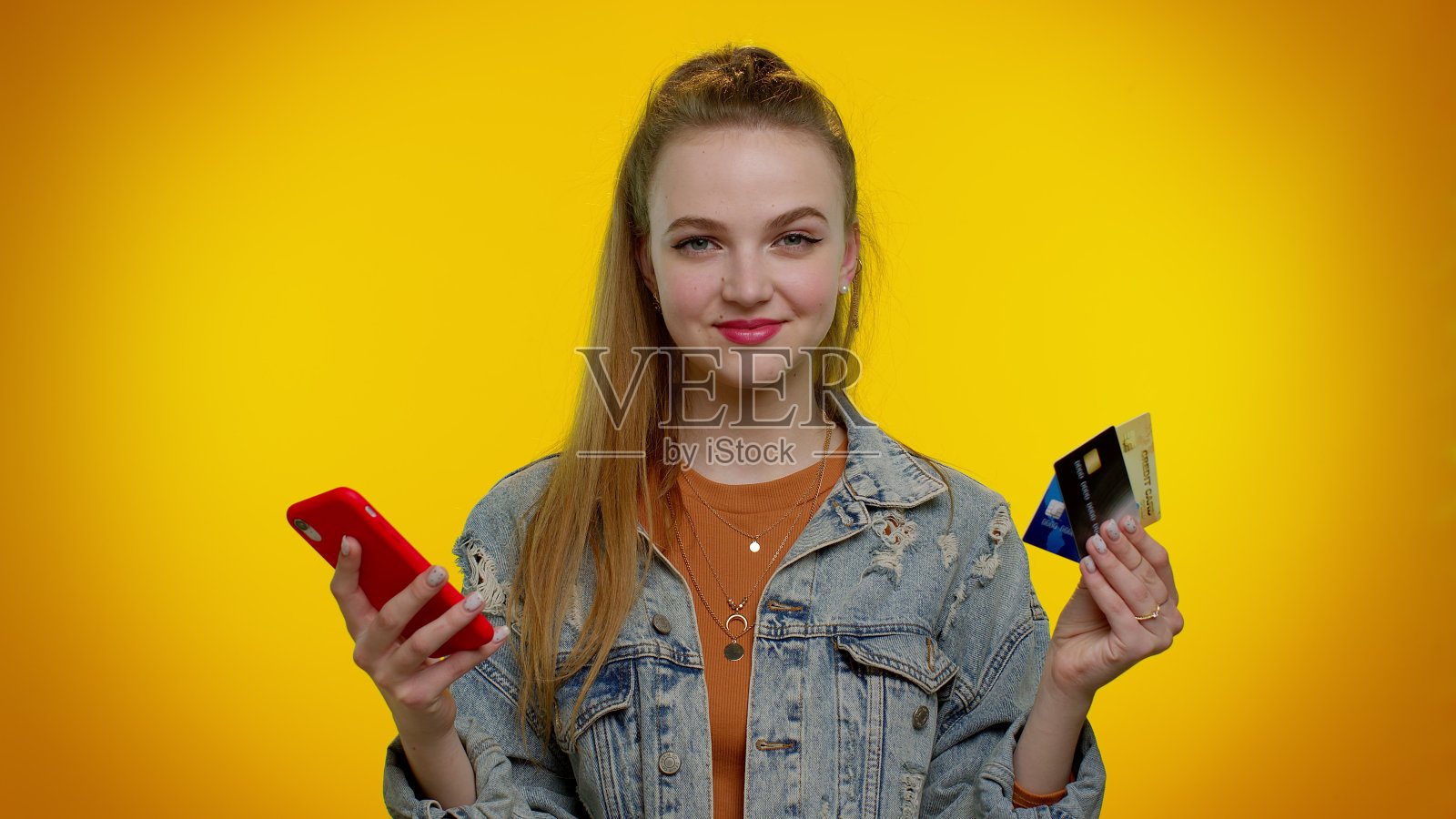 十几岁的女孩在转账时使用信用卡和智能手机，进行网上购物照片摄影图片