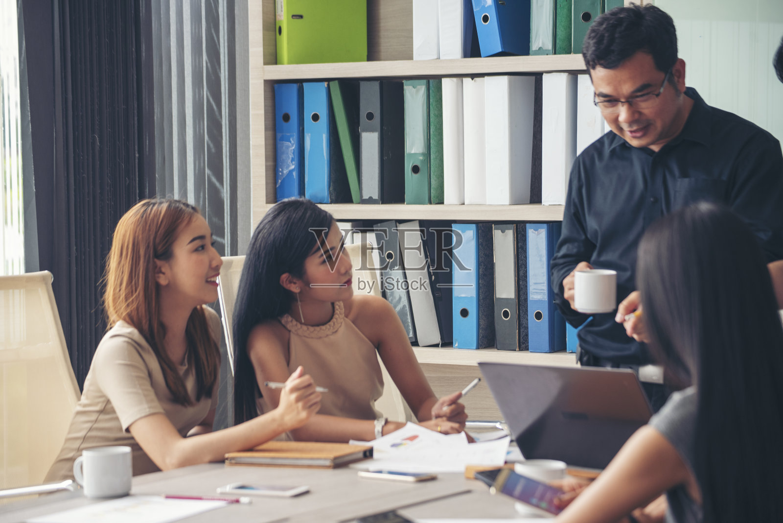 幸福多元化商务团队会议公司办公室办公桌在公司会议室。亚洲团队的合作伙伴头脑风暴讨论，多民族的人坐在一起分享想法，团队在会议室照片摄影图片