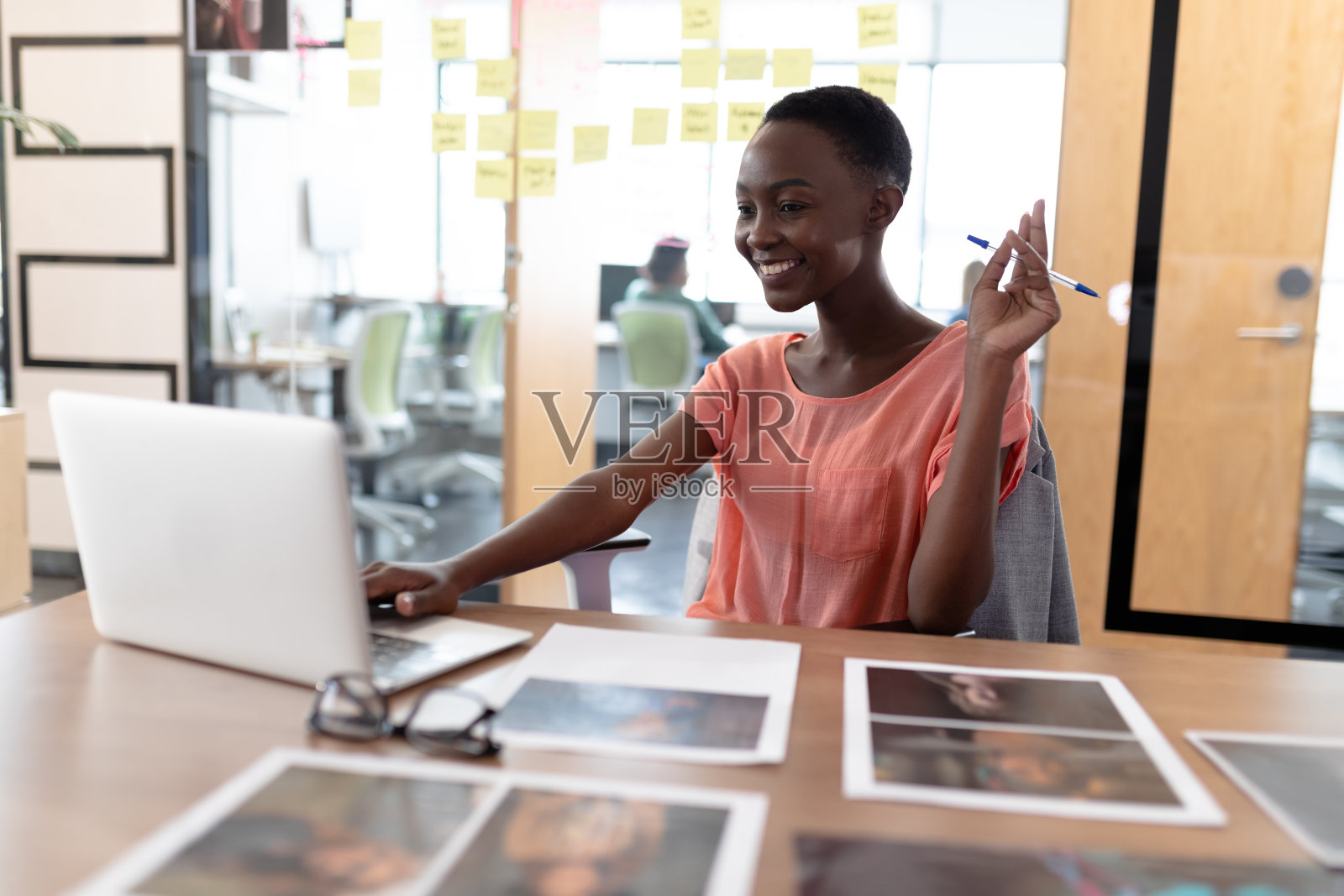 快乐的非裔美国女商人坐在桌子上用笔记本电脑进行视频通话照片摄影图片