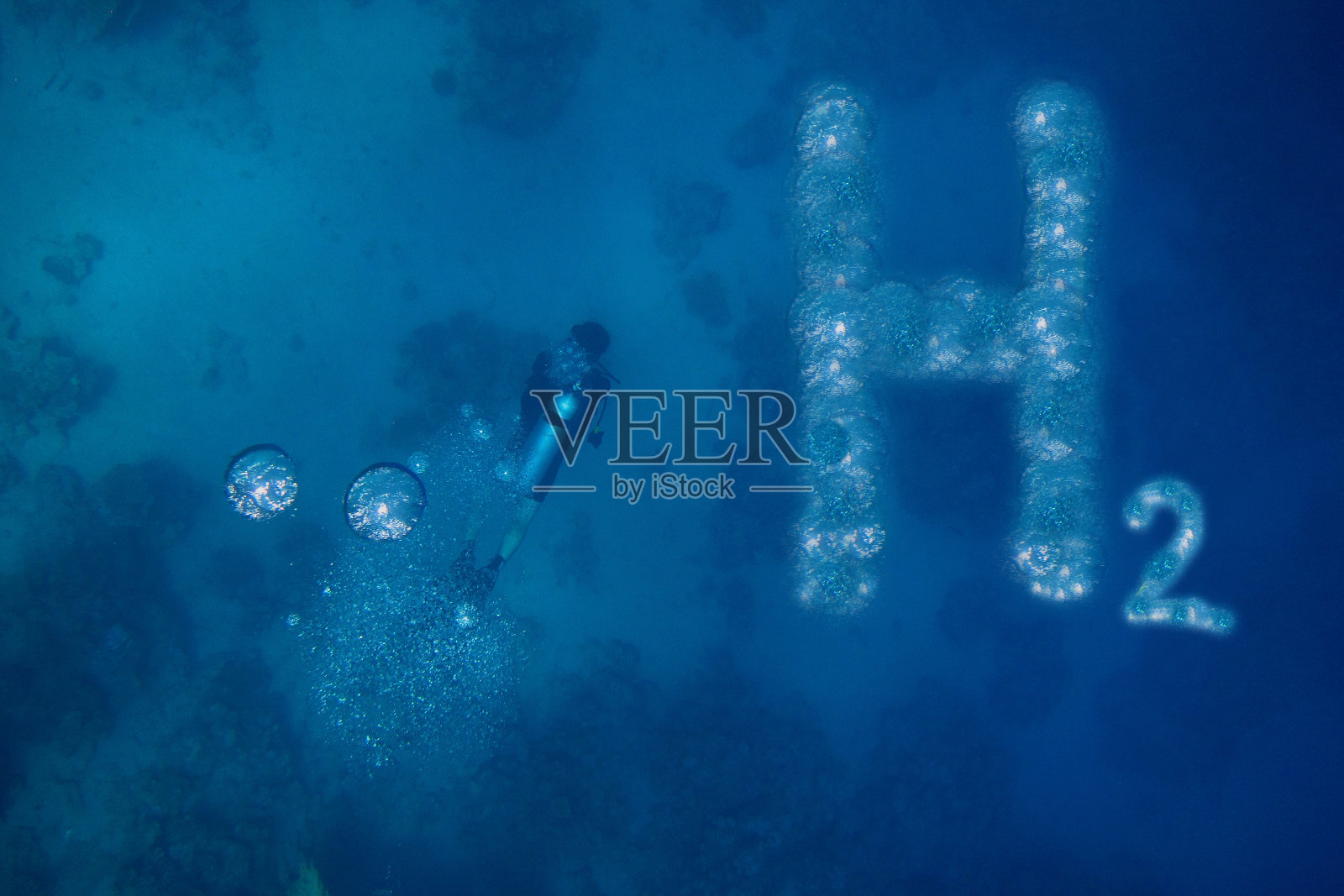氢字母和一个潜水员在蓝色的水中气泡照片摄影图片