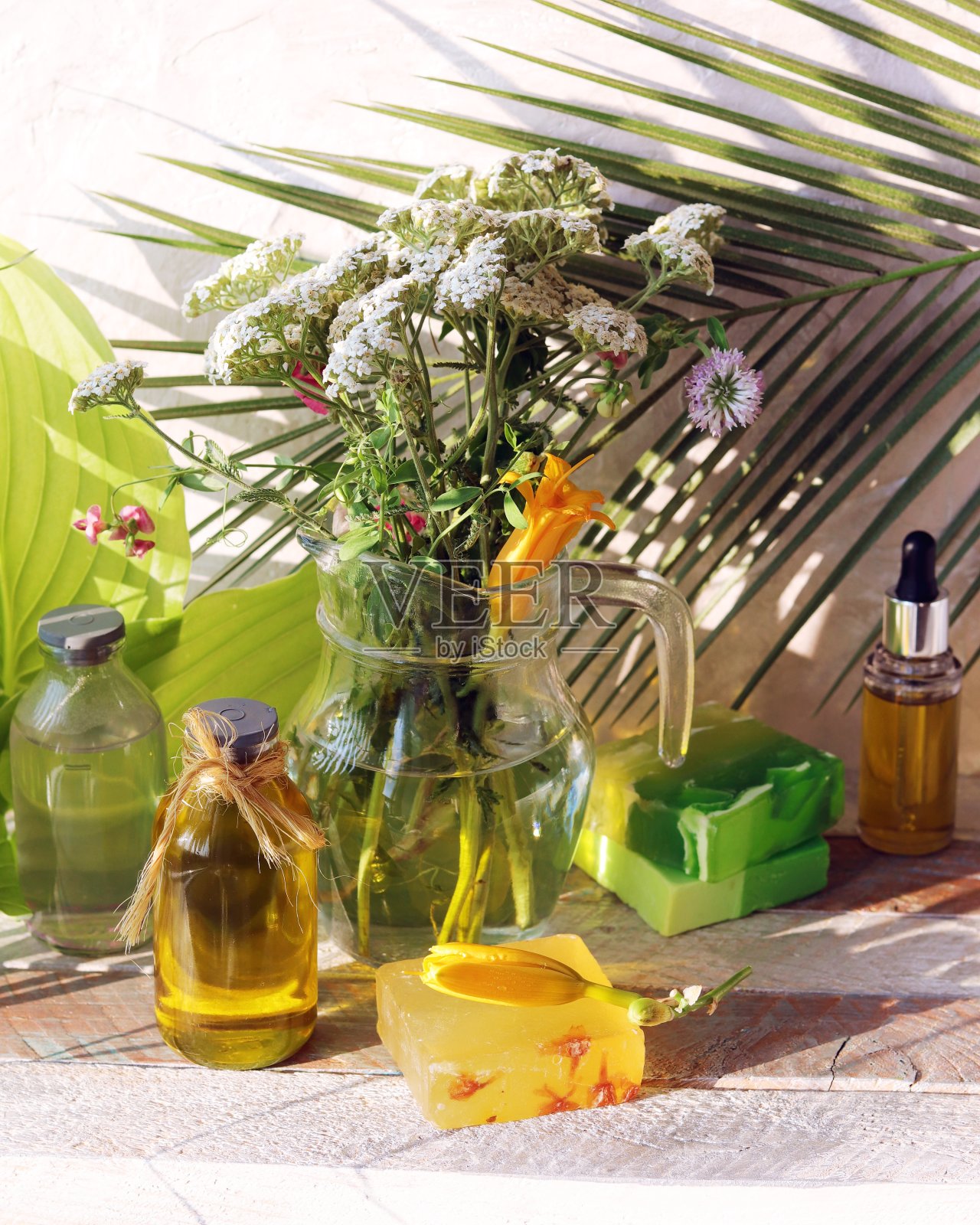 玻璃罐里放着一束药草，木桌上放着肥皂照片摄影图片