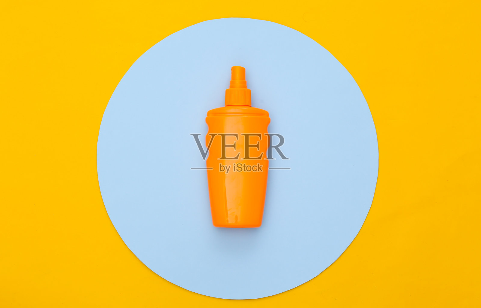 防晒瓶在黄色的背景和蓝色的圆圈。皮肤的保护。海滩度假。俯视图照片摄影图片