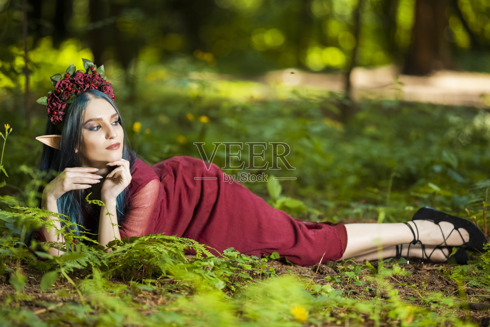 可爱的高加索女孩在花花环和艺术精灵耳朵摆姿势在夏季森林地面的全长肖像。水平射照片摄影图片