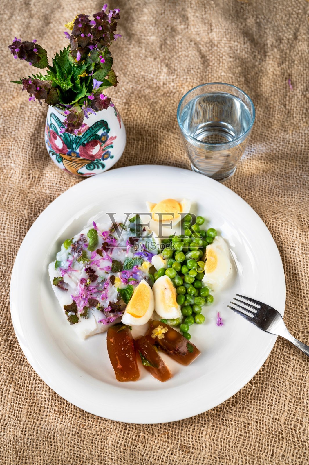 黄麻上有2种春花肉冻、水和花束。照片摄影图片
