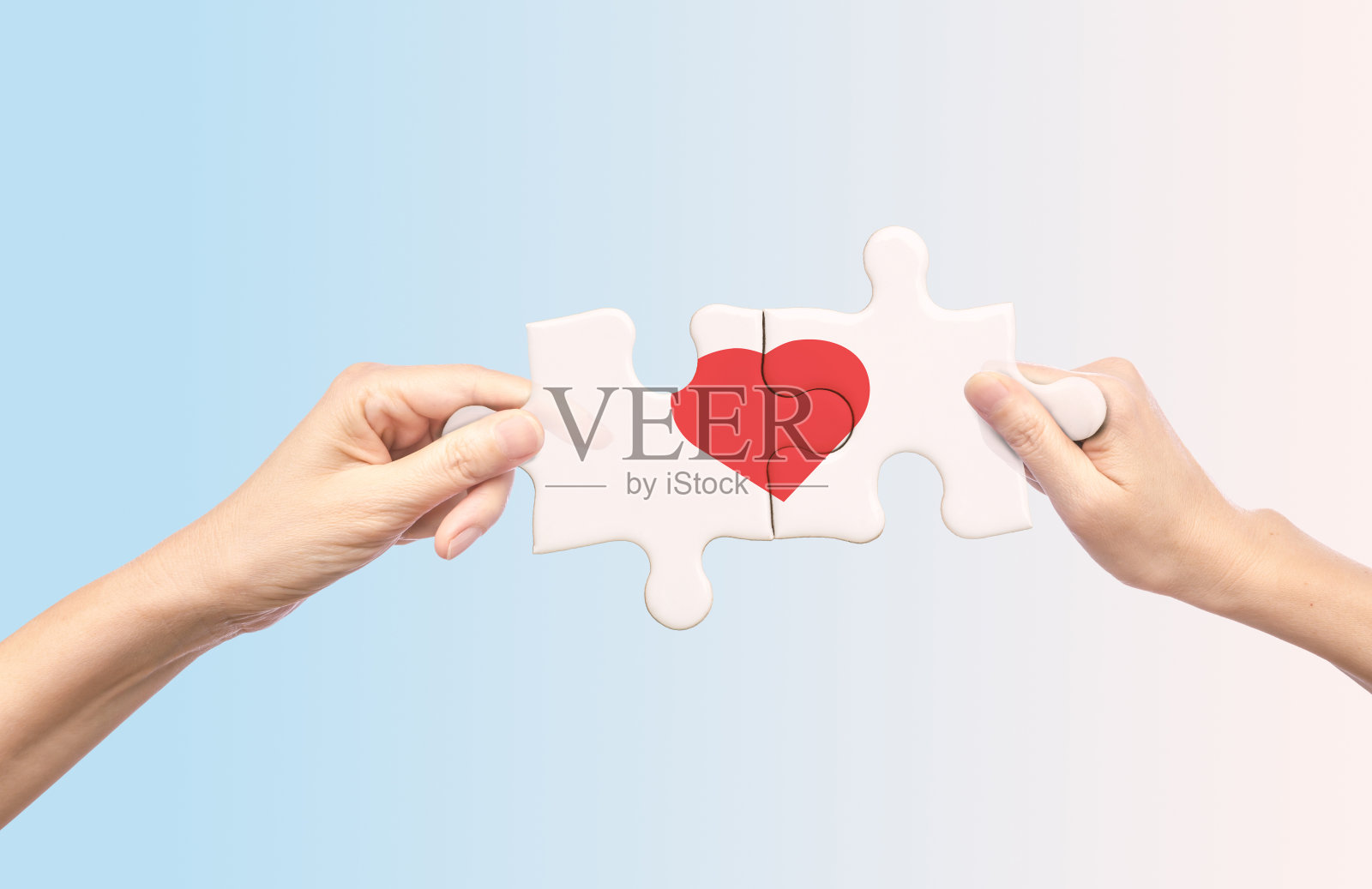 手拿着里面有红色心形的白色拼图照片摄影图片