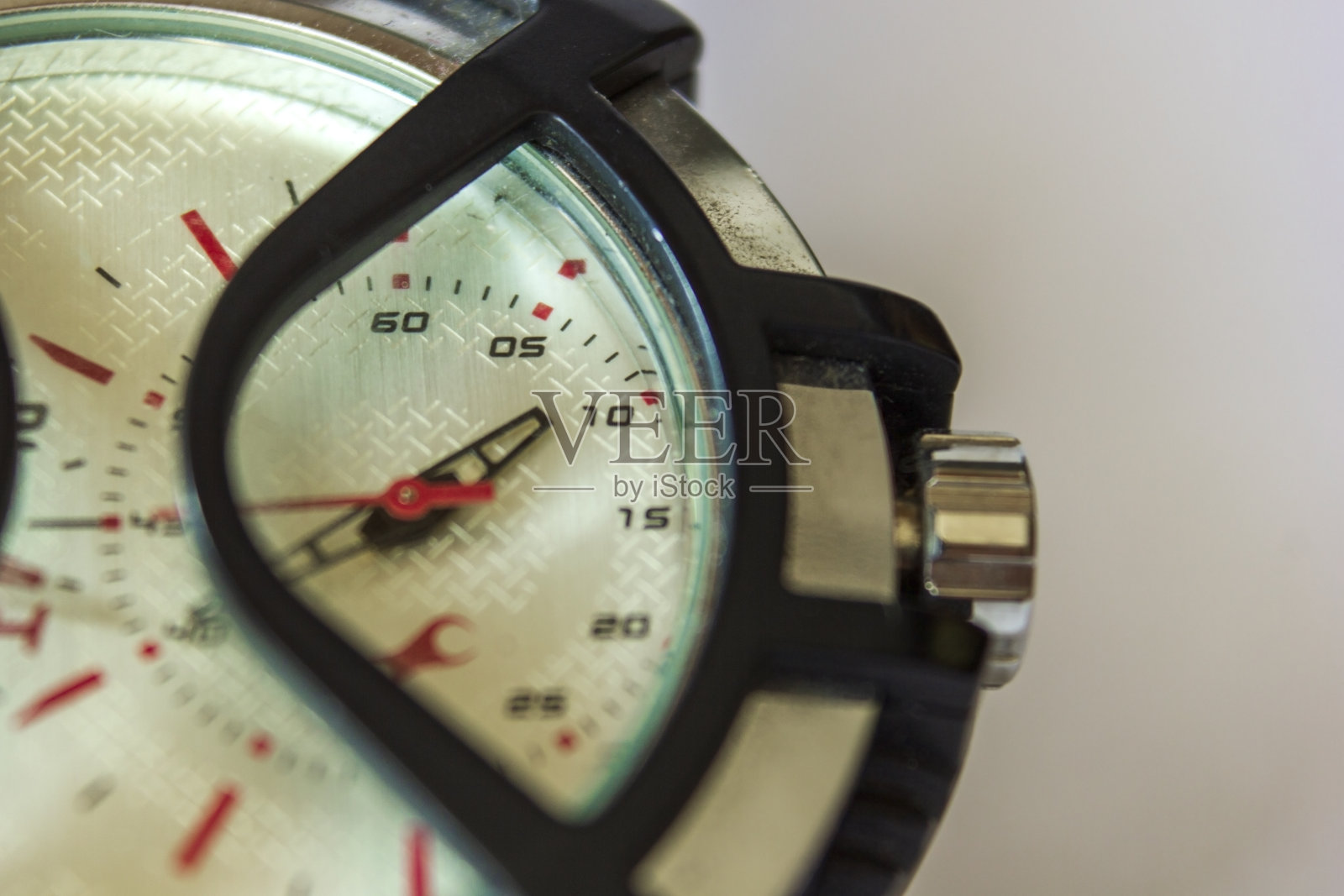 微距拍摄带有保护罩的手表，拨向右边可通过更换指针来设定时间。照片摄影图片