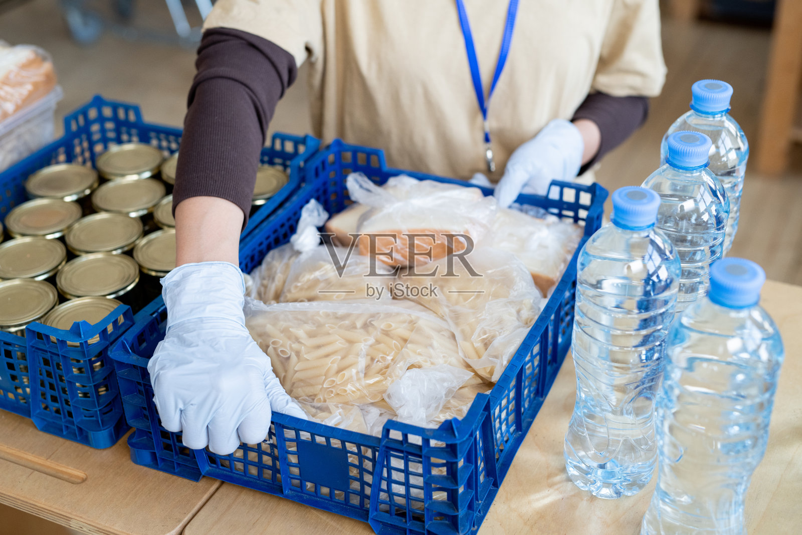 戴手套的人把装食品的大盒子放在桌子上照片摄影图片