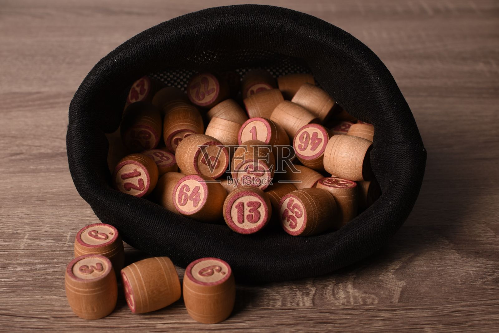木制的乐透木桶在黑色的袋子里放在一个木制的轻桌上。表宾果游戏。桶彩票。照片摄影图片