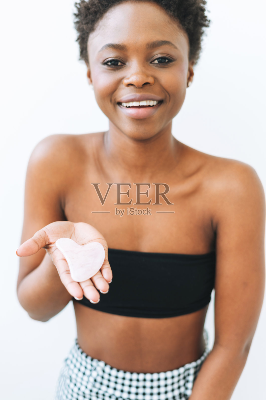 美丽的肖像美丽的年轻非洲裔美国妇女与石玫瑰石英铲在手近脸孤立在白色的背景照片摄影图片