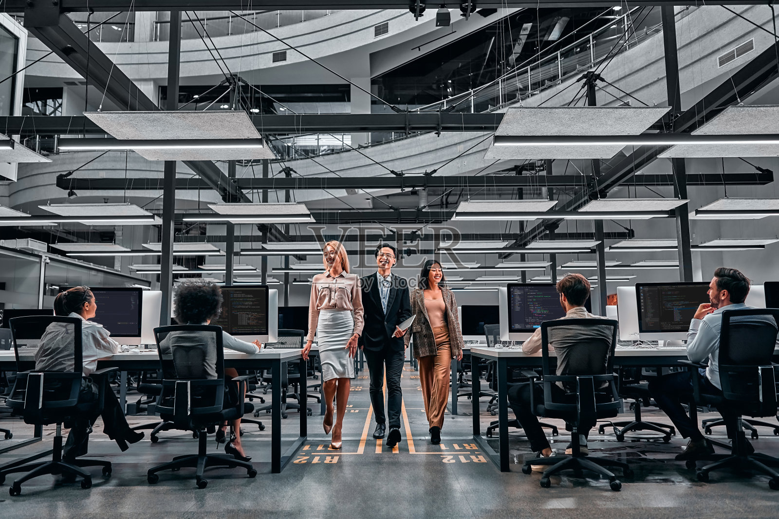 在宽敞的办公室里讨论工作的三位商务人士照片摄影图片