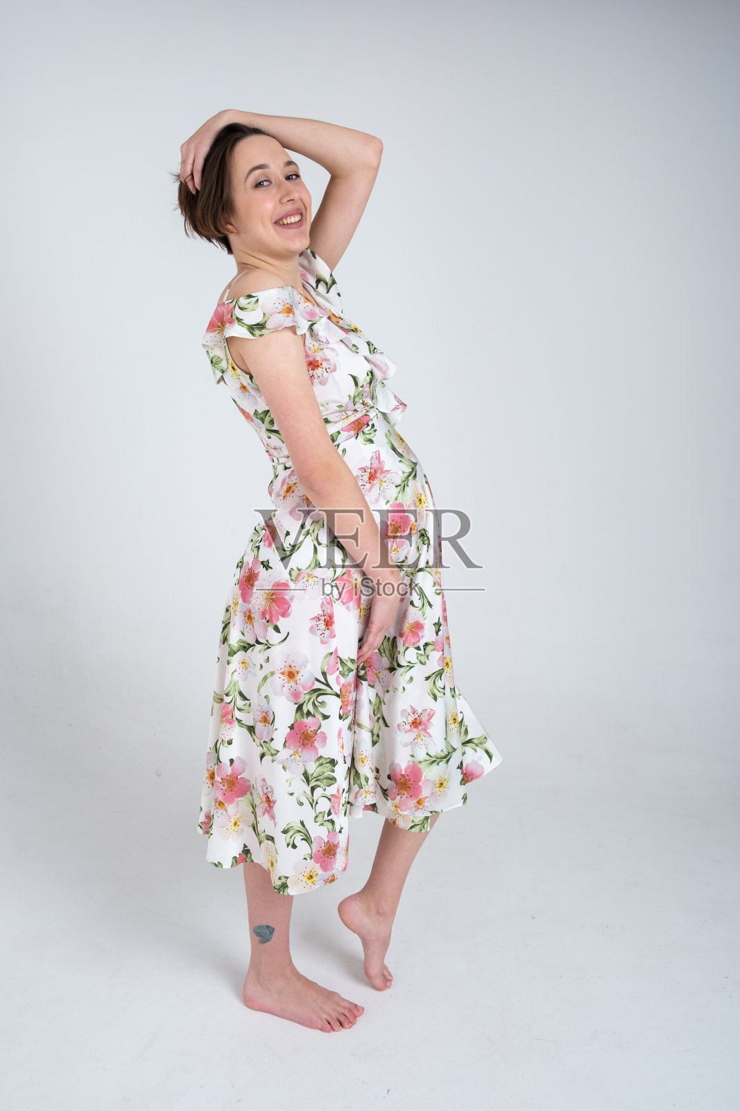 工作室肖像欢快的年轻孕妇在夏天穿着白色灰色的背景，快乐怀孕的概念照片摄影图片