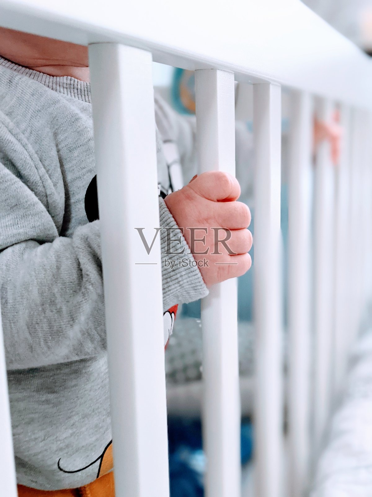 一个婴儿的手抓住他的婴儿床的栏杆的细节照片摄影图片