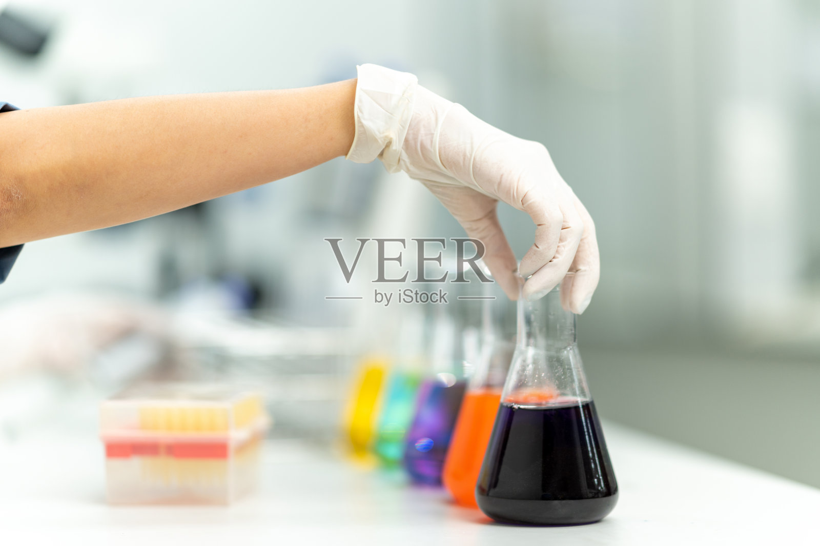 一位女科学家正在测试实验室的化学研究。照片摄影图片