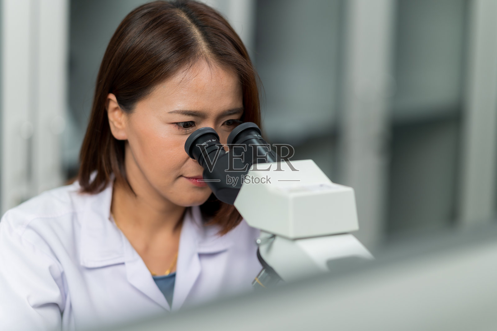 女技术员在实验室做显微镜分析工作照片摄影图片