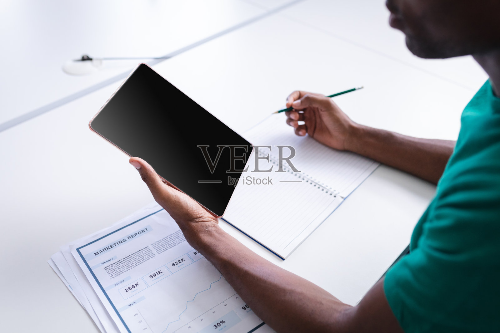 非裔美国商人坐在办公室里用平板电脑进行视频通话并做笔记照片摄影图片