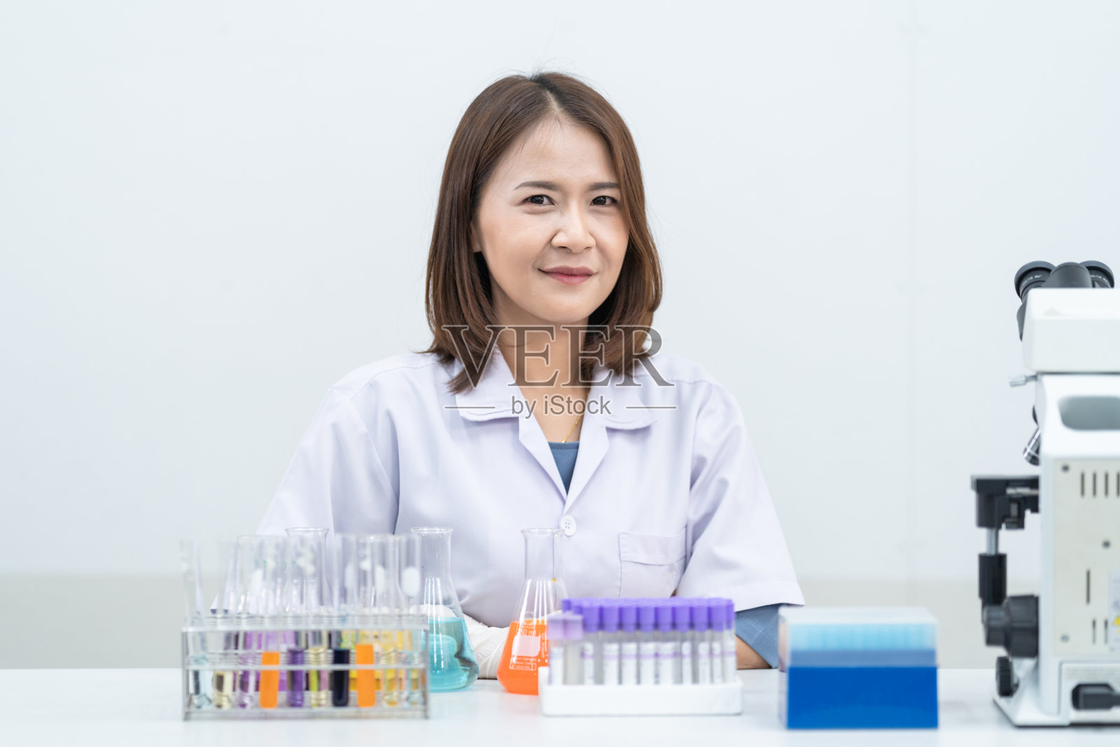 女研究员，女医生，女科学家，女实验室助理在现代实验室里用塑料医用管进行研究、检查科学实验的年轻女性研究员、医生、科学家或实验室助理教育库存图片照片摄影图片