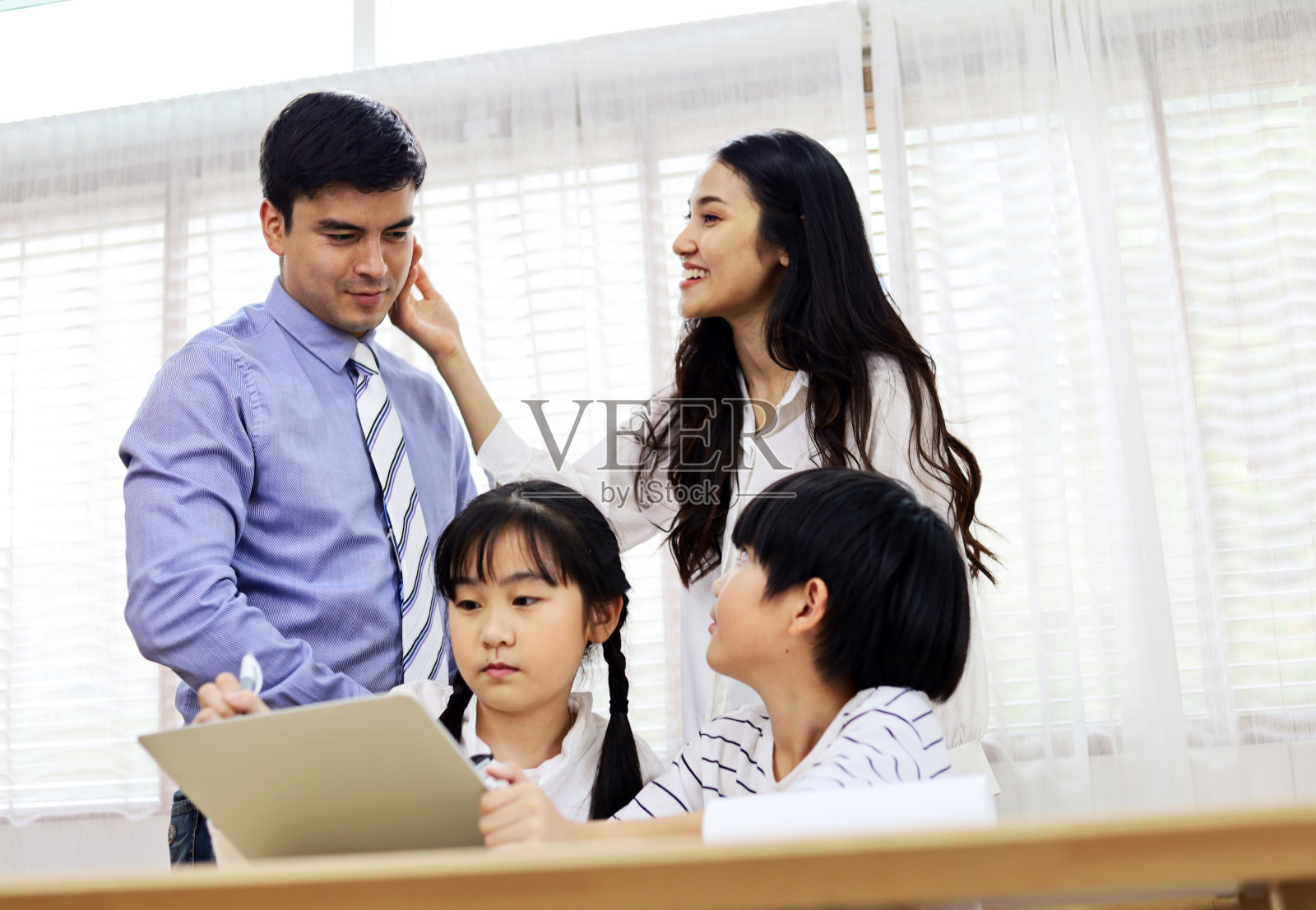 快乐两个孩子在假期周末在家用智能手机学习。照片摄影图片