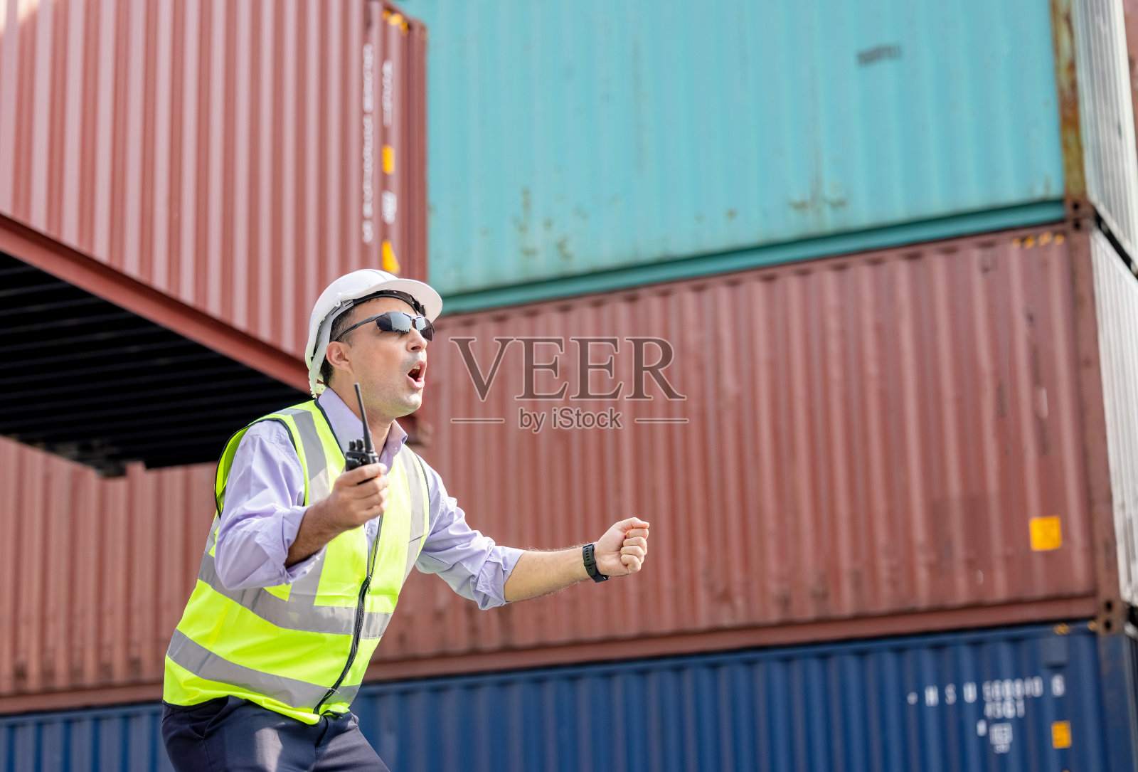 在货柜码头，产业工人正在控制货柜的装车照片摄影图片