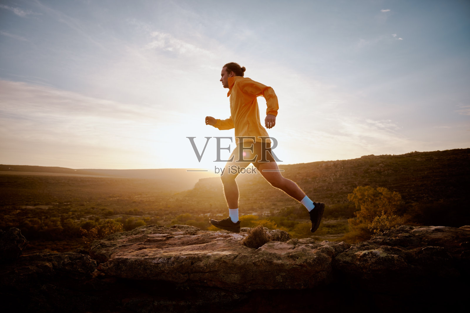 一个健壮的年轻运动员在日出时跑上山照片摄影图片