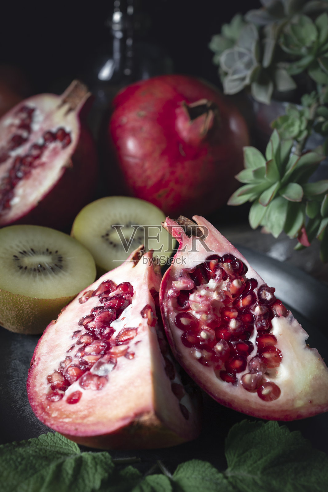 石榴种子。新鲜水果的静态生活与黑暗的背景。照片摄影图片