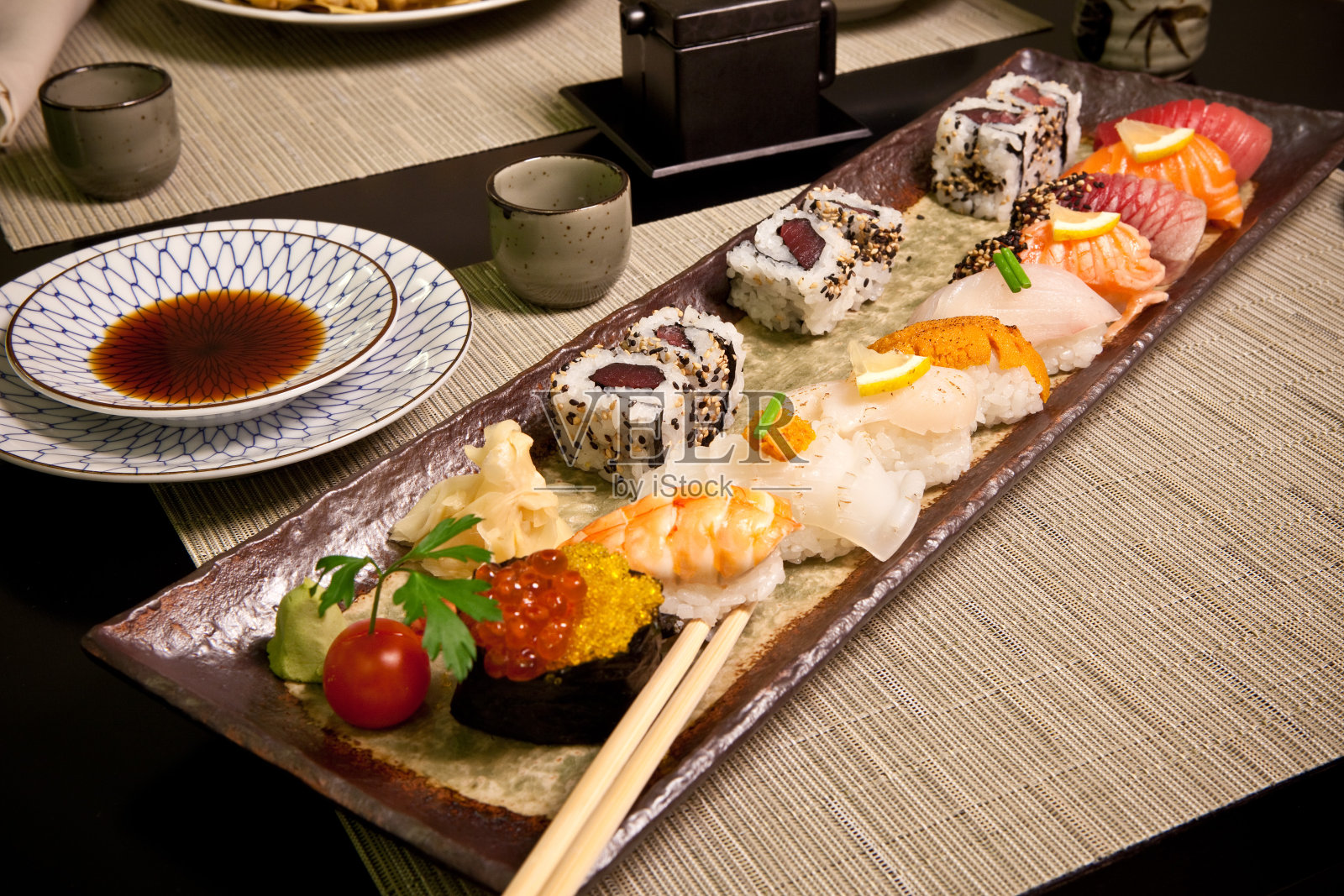 日本料理餐厅的寿司——酱油盘、筷子、寿司排、芥末卷、红鱼子酱、照片摄影图片