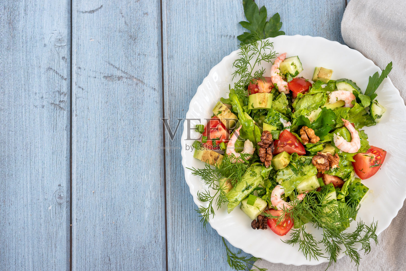 虾仁沙拉，鳄梨沙拉，青菜沙拉，樱桃番茄，香草和橄榄油，柠檬酱。健康的食物照片摄影图片