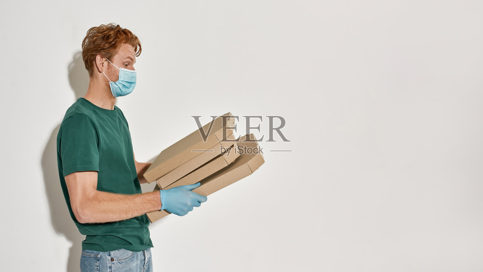 年轻的白人快递员拿着披萨盒照片摄影图片