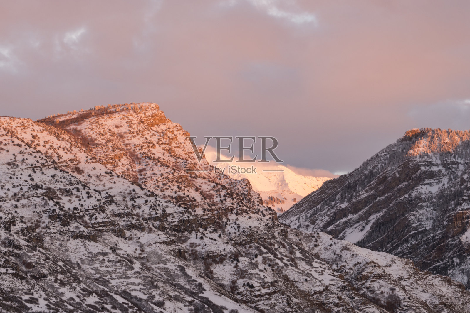 白雪皑皑的春天，寡妇峰和周围的山脉的日落照片摄影图片