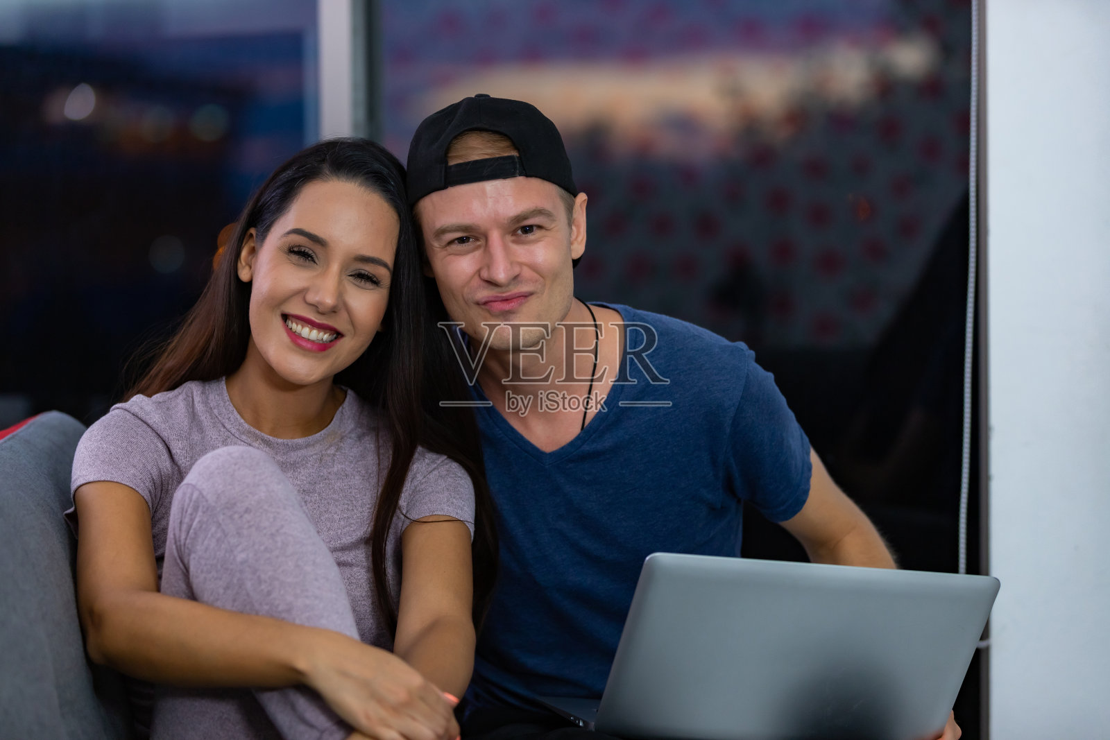 年轻夫妇在家里的沙发上用笔记本电脑放松和享受。照片摄影图片