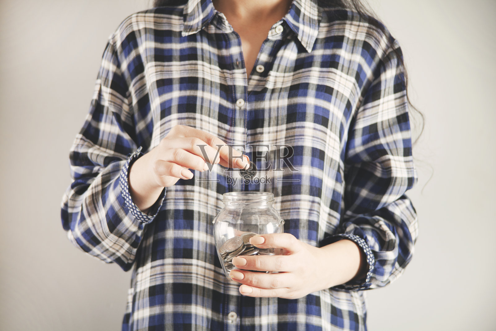 手里拿着存钱罐和硬币的女人照片摄影图片