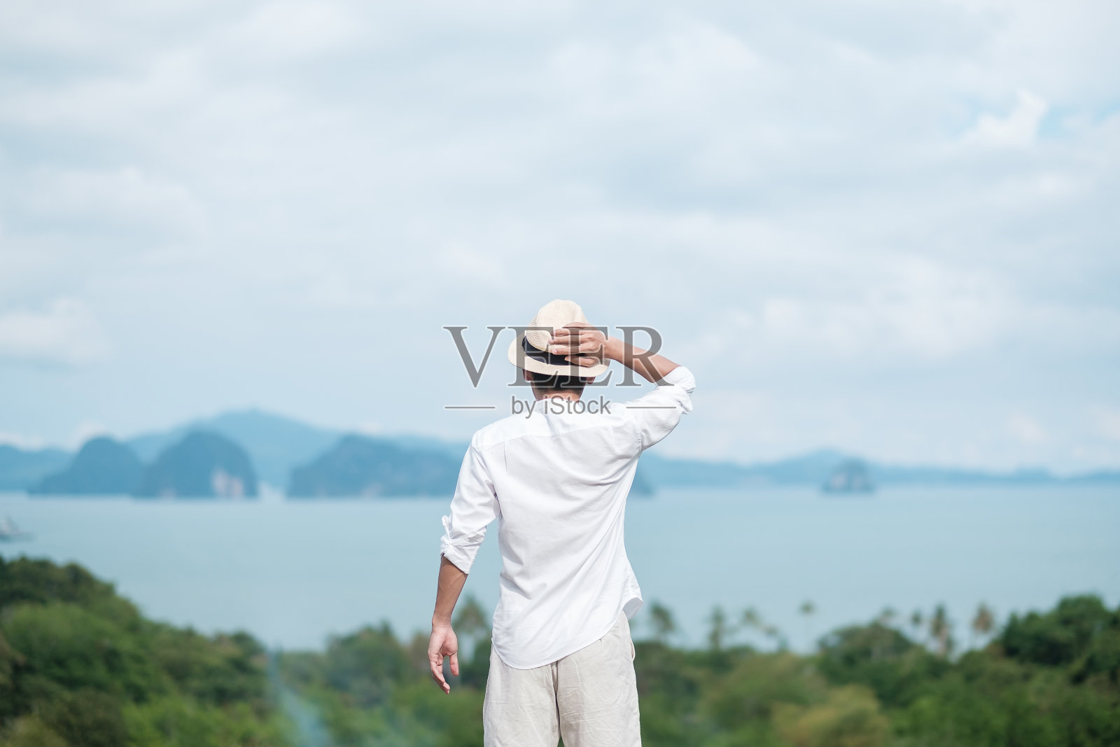 戴着帽子的游客站在海上放松。旅游，夏季和假期的概念照片摄影图片